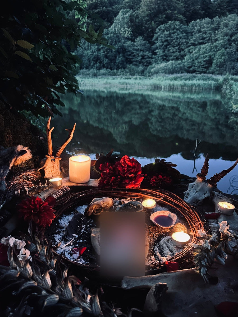 Candles burning around a ritual circle by a lake at dusk