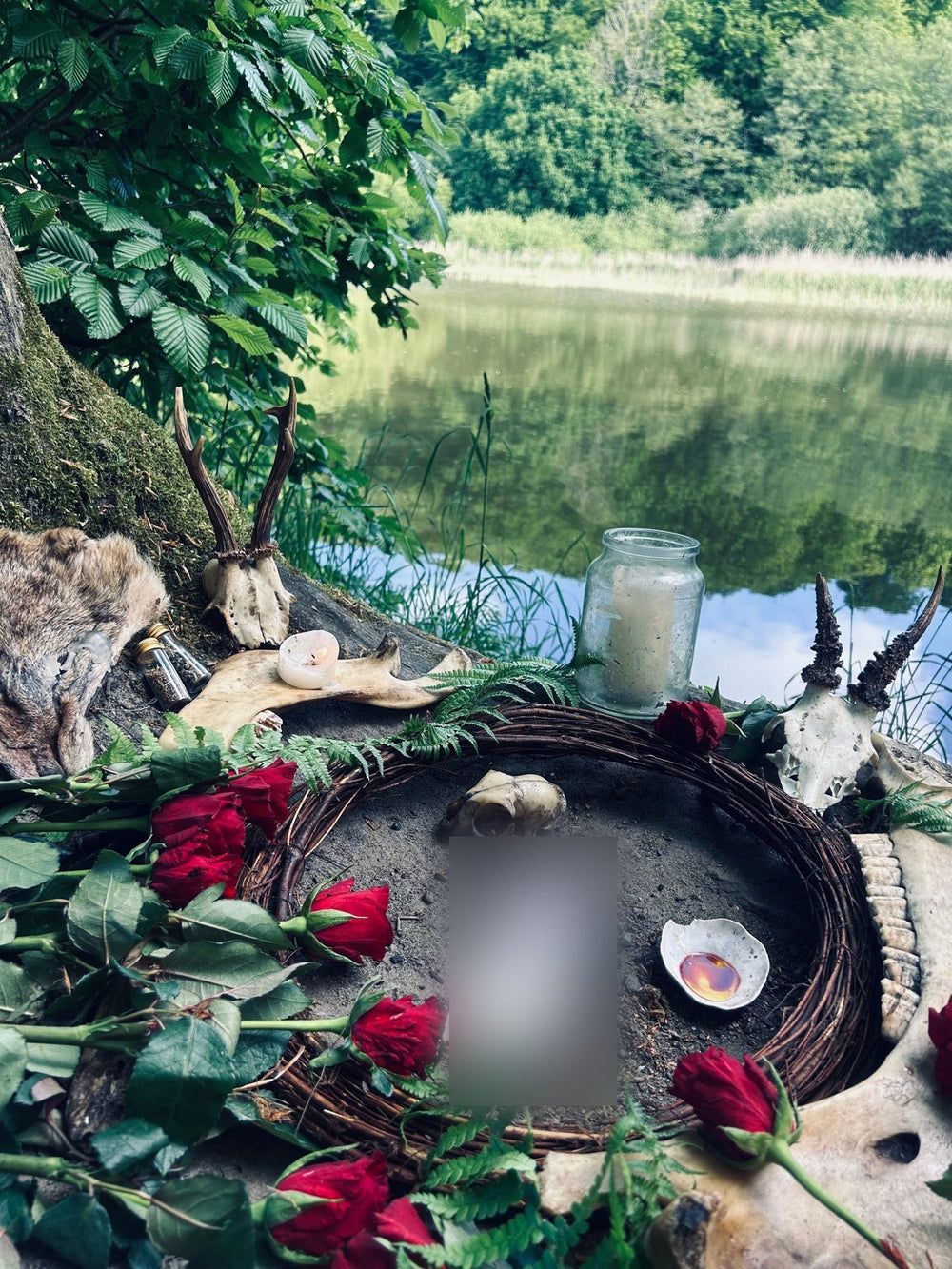 Red roses and ferns around a ritual circle by a lake