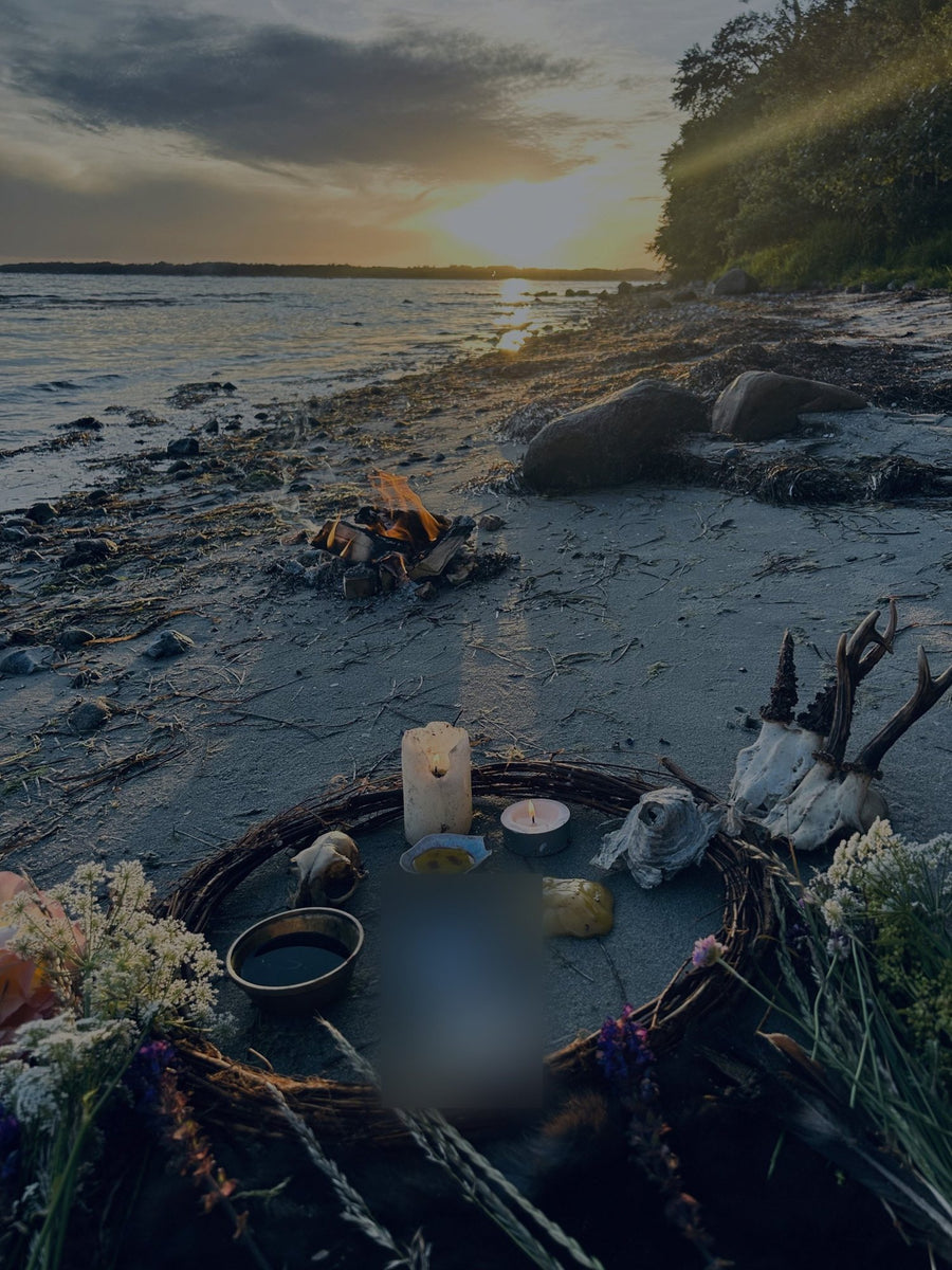 A fire on the beach at sunset, with a ritual circle in the foreground